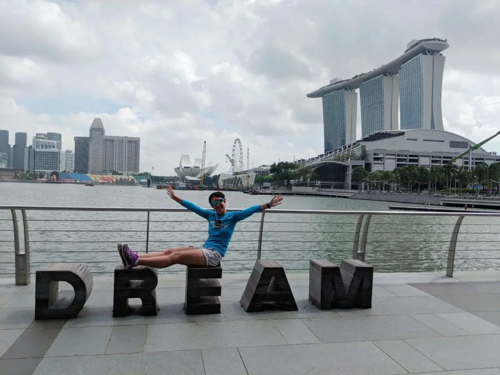 Sitting on a seat that says "DREAM" and overlooking the Marina Bay