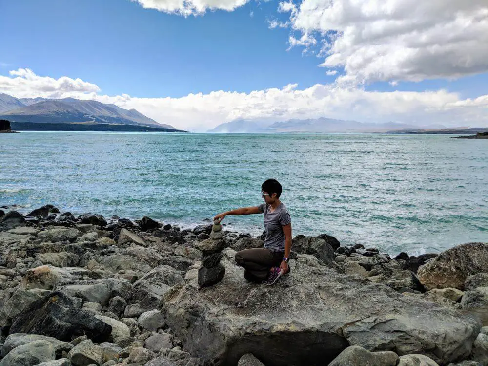 Jackie Szeto, Life Of Doing, stacks rocks during the New Zealand Road Trip and while visiting Lake Pukaki, New Zealand