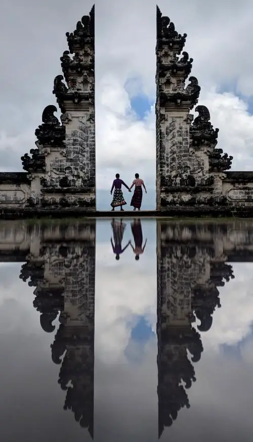 Justin Huynh and Jackie Szeto, Life Of Doing, hold hands at Pura Lempuyang's Gateway to Heaven in Bali, Indonesia