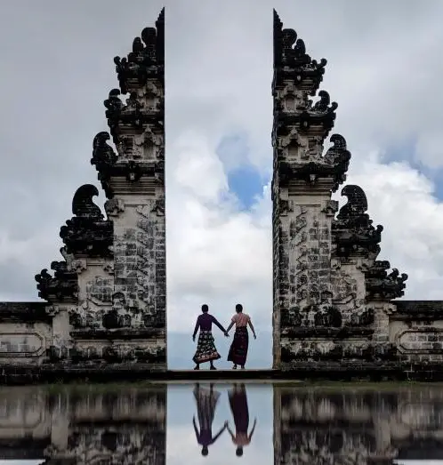 Justin Huynh and Jackie Szeto, Life Of Doing, hold hands at Lempuyang Temple's Gateway to Heaven, a perfect day trip from Ubud.