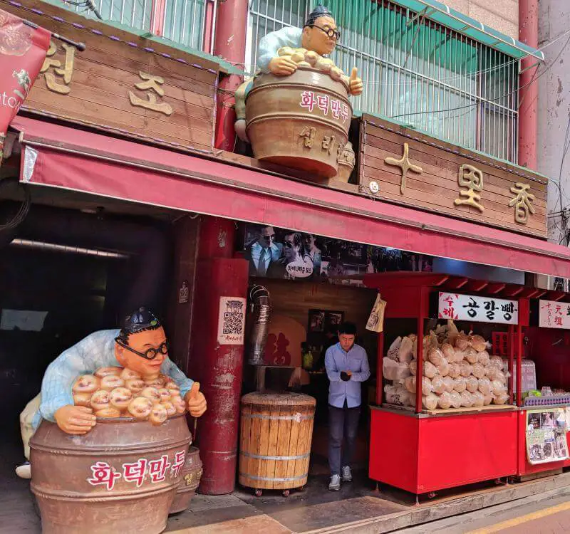 Incheon, South Korea One Day: Chinatown has two large sculpture of a man holding a barrel of fortune cookies