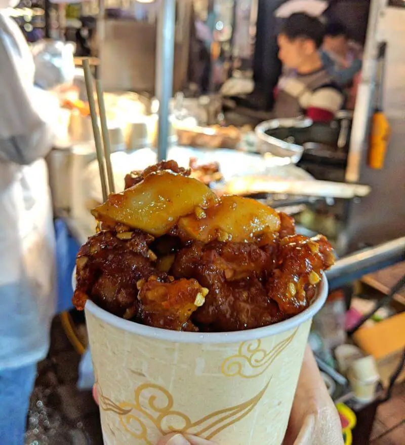 A cup of fried chicken and rice cakes in a spicy sauce in Myeongdong, Seoul, South Korea 