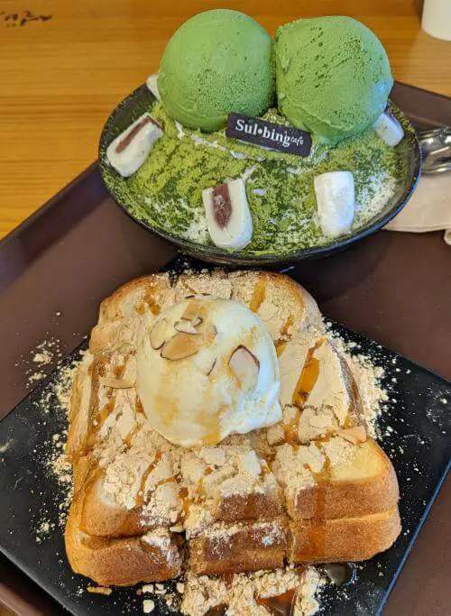 A plate with two pieces of toast with soy powder and ice cream and a bowl of green tea snow iced dessert and ice cream at Sulbing Cafe in Myeongdong, Seoul, South Korea