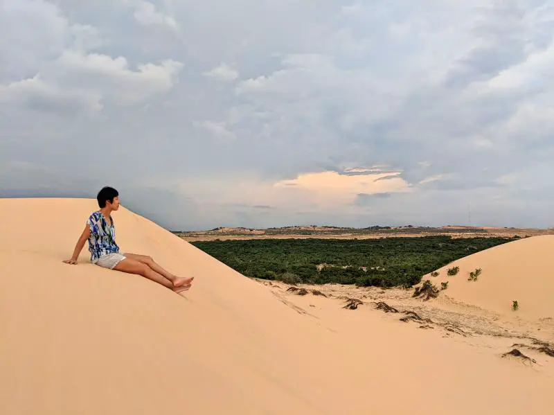 Jackie Szeto, Life Of Doing, sits on top of a sand dune in Mui Ne, Vietnam