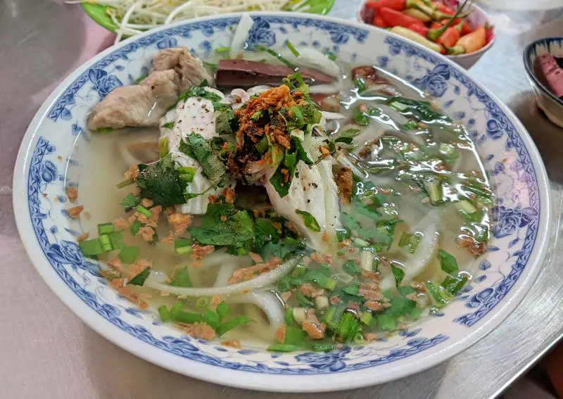 Hot bowl of bánh canh bột lọc which has banh canh noodles, fish cakes, pork bone, chicken, and fish cakes. It's a good place for breakfast in Phu Quoc, Vietnam.