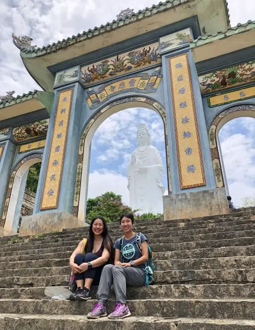 Jackie Szeto, Life Of Doing, and her sister sit in front of Linh Ung Pagoda in Danang. It is a lovely place to visit during your 3 days in Danang, Vietnam.