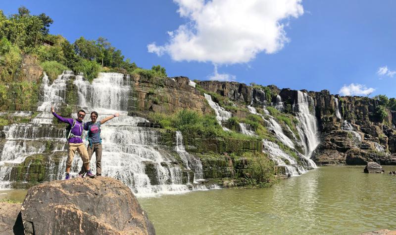 Justin Huynh and Jackie Szeto, Life Of Doing, is in front of the Pongour Waterfall in Dalat, Vietnam