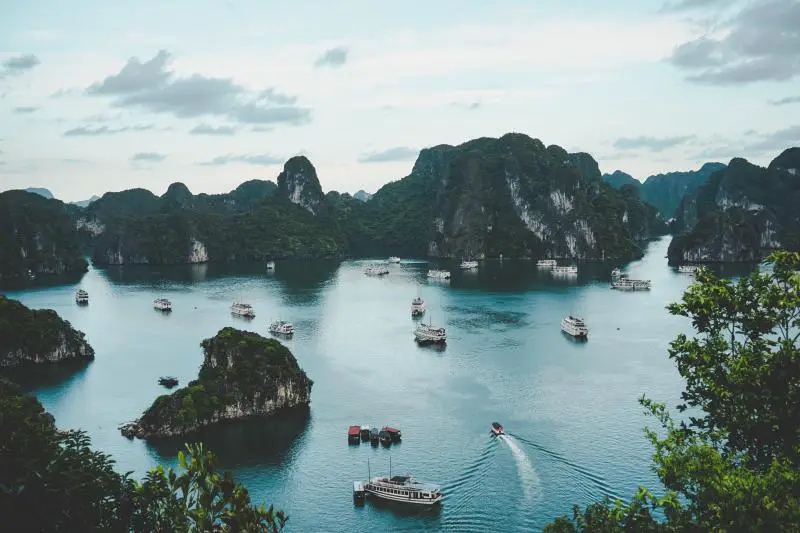 Panoramic view of Halong Bay, one of the UNESCO World Heritage sites in Vietnam. The junk boats navigates through the calm bay waters as visitors observe the limestone karsts.