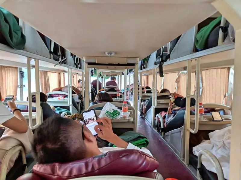 Inside of the Vietnam overnight bus (sleeper bus). There are three rows of seating with two levels.