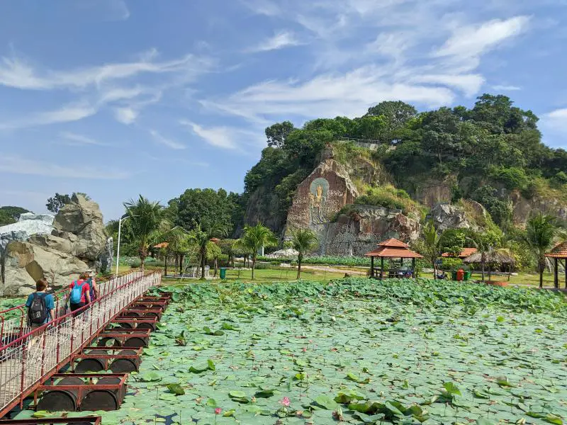 People crossing the bridge over the lotus pond at Buu Long Theme Park in Dong Nai, Vietnam.