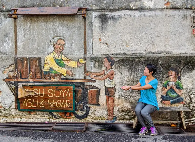 The "Susa Soya Asli and Segar" Street art of a seller passing out bowls of soy milk in Penang George Town.