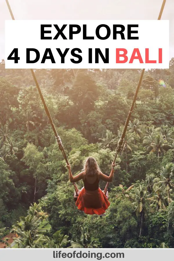 A woman in a red dress is on a Bali swing with the forest area underneath her. Check out our four days in Bali itinerary for more information on what to do in Bali.