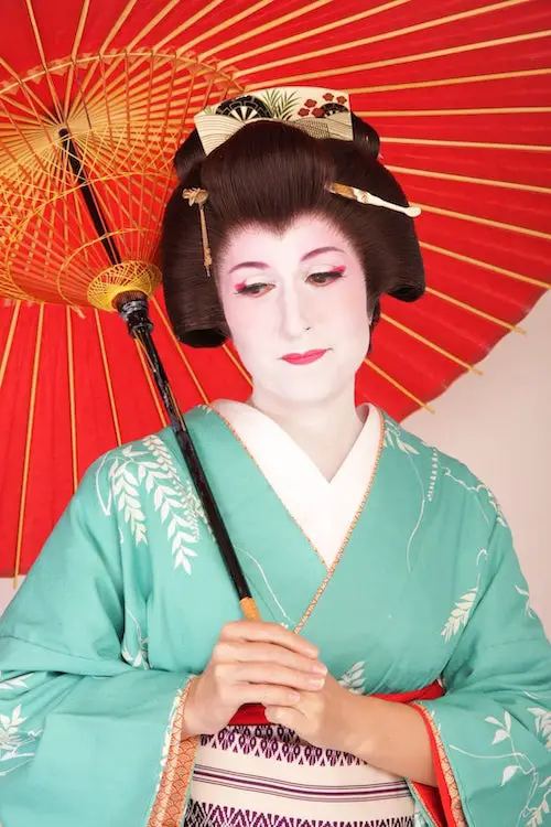 A woman dresses up as a geisha in a turquoise kimono and has a photoshoot in Tokyo, Japan.