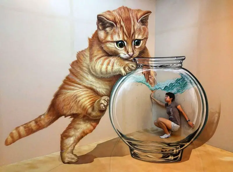 Jackie Szeto, Life Of Doing, is at Artinus 3D Art Museum in Ho Chi Minh City, Vietnam. She pretends to be in a fish bowl as a cat reaches into the fish bowl.