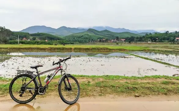 A red and black bicycle stands in front of the farming fields in Bong Lai Valley, a rural area of Phong Nha, Vietnam