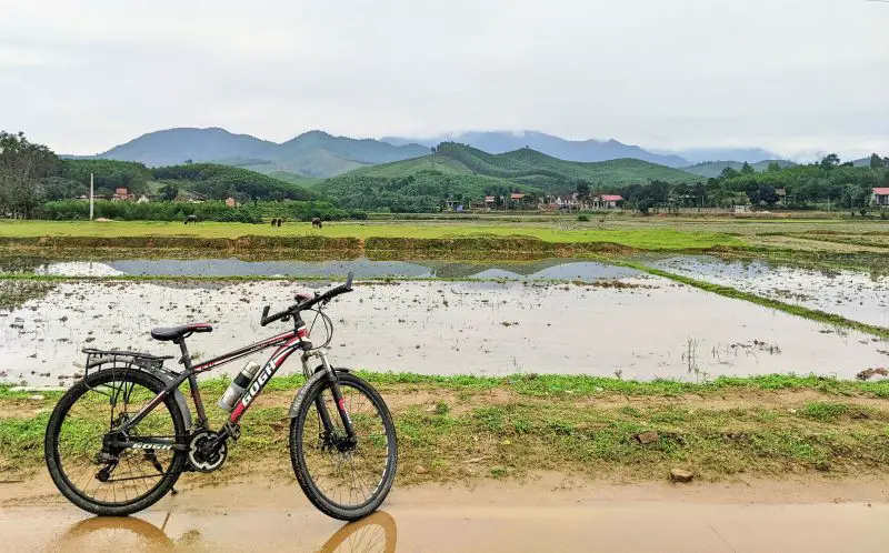 A red and black bicycle stands in front of the farming fields in Bong Lai Valley, a rural area of Phong Nha, Vietnam