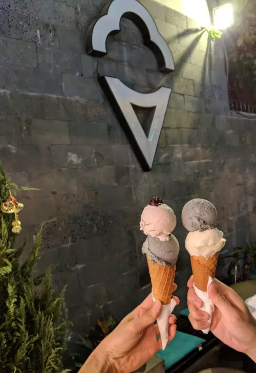 Two hands holding two scoops of ice cream with sugar cone at Puppy and Cesar in Ho Chi Minh City, Vietnam
