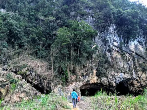 Jackie Szeto, Life Of Doing, and a group of hikers walk towards the entrance of Hang En Cave in Phong Nha, which is one of the best hikes to do in Vietnam