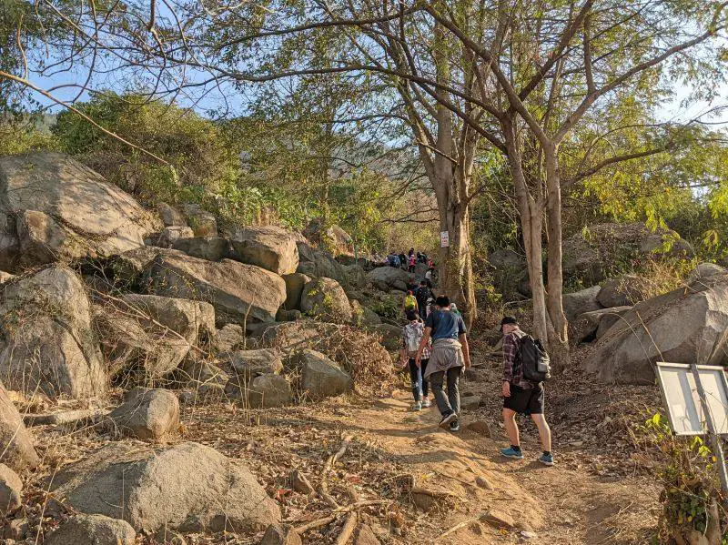 Groups of hikers walk up the dirt path on the Black Virgin Mountain trail in Vietnam