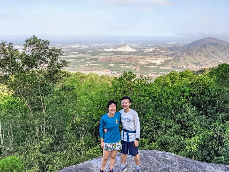 Jackie Szeto and Justin Huynh, Life Of Doing, stand on a rock with the overview of Ba Ria-Vung Tau area on Nui Dinh Mountain, Vietnam