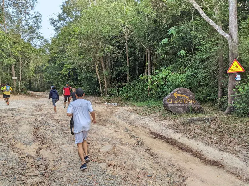 Groups of runner along the dirt path veering left to the temple route at Nui Dinh Mountain.