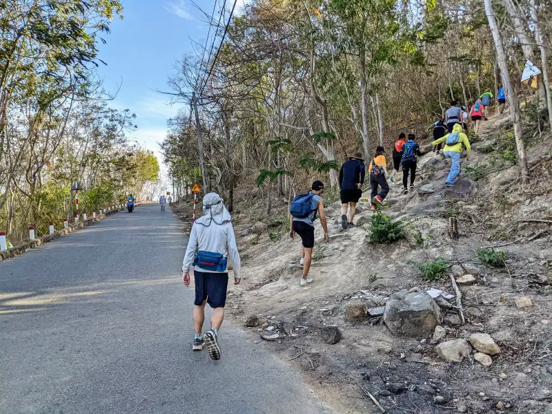 Justin Huynh, Life Of Doing, and a dozen hikers start the Nui Lon Big Mountain hiking trail from the road in Vung Tau, Vietnam
