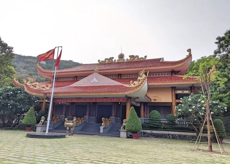 A building with a red roof and golden dragons in the Historical Relic area of Minh Dam.