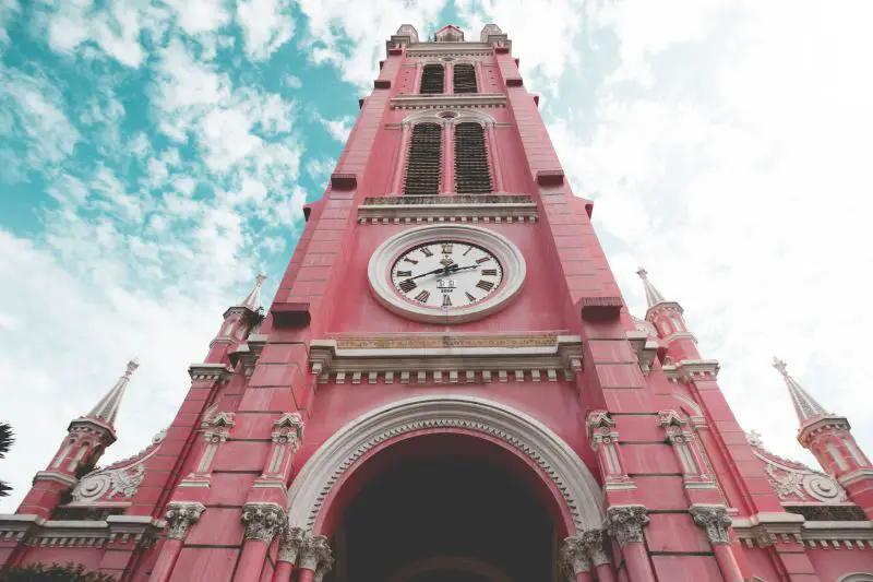 The top part of the pink and white Catholic church with a clock at the Tan Dinh Church in Ho Chi Minh City