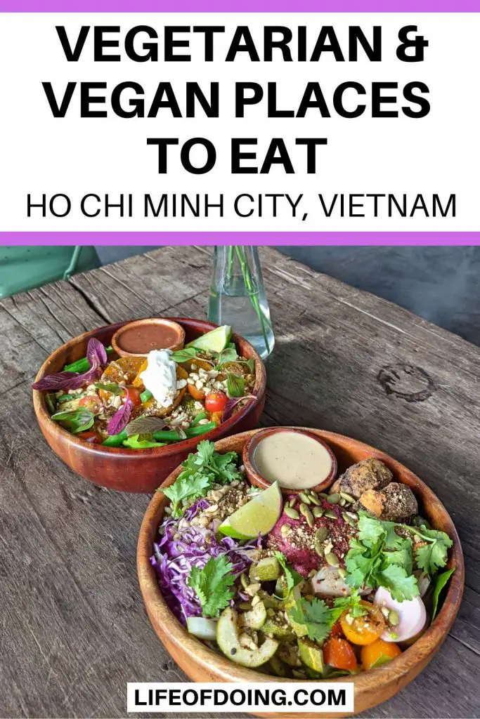 Two colorful salads in wooden bowls on top of a wooden table at a vegetarian and vegan restaurant in Ho Chi Minh City, Vietnam