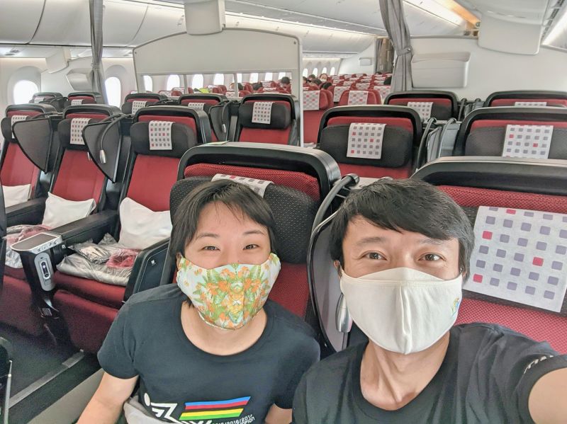 Jackie Szeto and Justin Huynh, Life Of Doing, sitting on a mostly empty plane on Japan Airlines from Ho Chi Minh City, Vietnam to Narita-Tokyo, Japan.