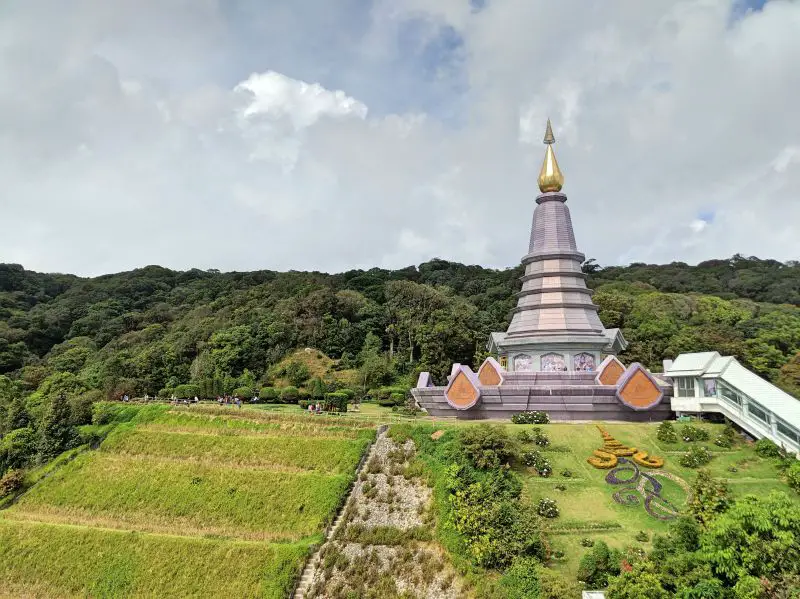 A purple and gold temple on top of a hill at Doi Inthanon National Park in Chiang Mai, Thailand