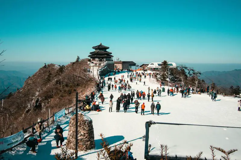 Crowds of people walking along the snowy path at Deogyusan National Park, South Korea