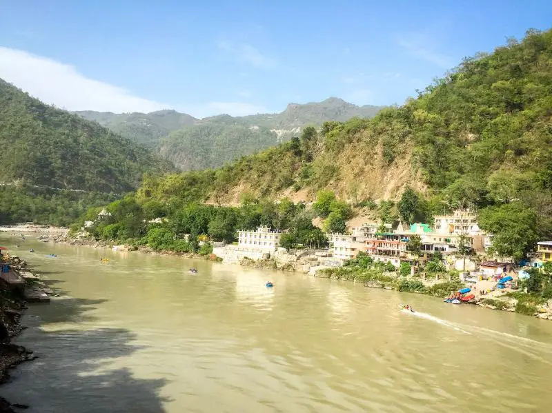 Kayaking and other boats along a river in Rishikesh, India