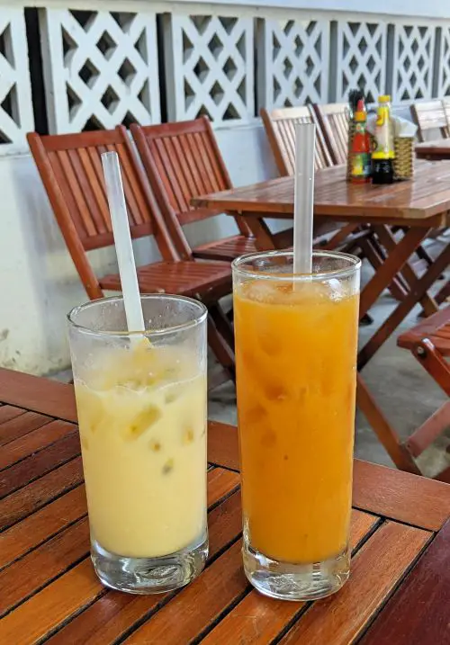 Two glasses of iced fruit juices on a wooden table in Vietnam