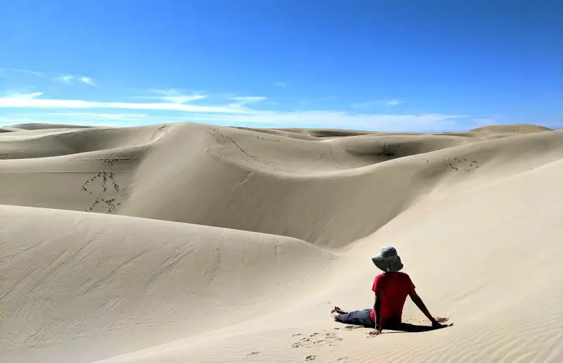 Jackie Szeto, Life Of Doing, sits in the sands overlooking the dunes at Oceano Dunes near Pismo Beach, California