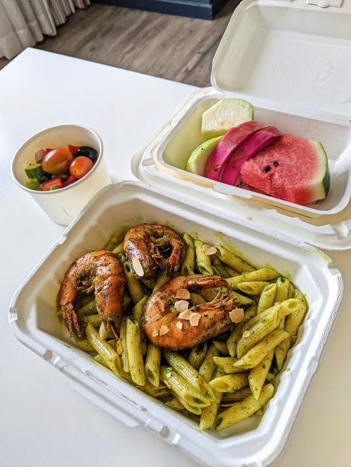 Pesto penne with three shrimps, fruit, and cucumber salad