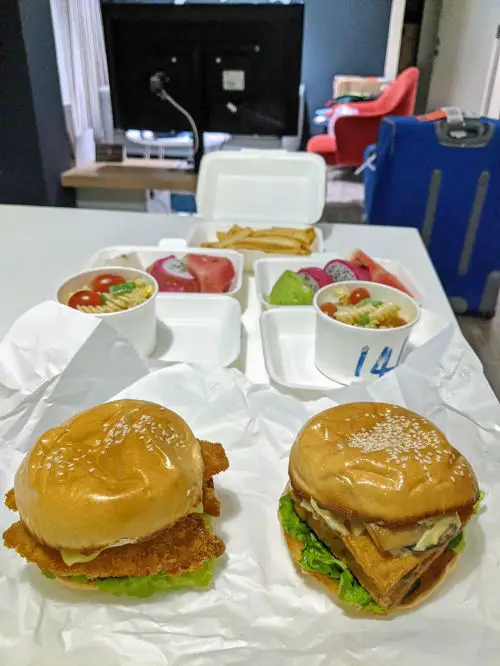 Chicken burger and tofu burger with pasta salad and fruit