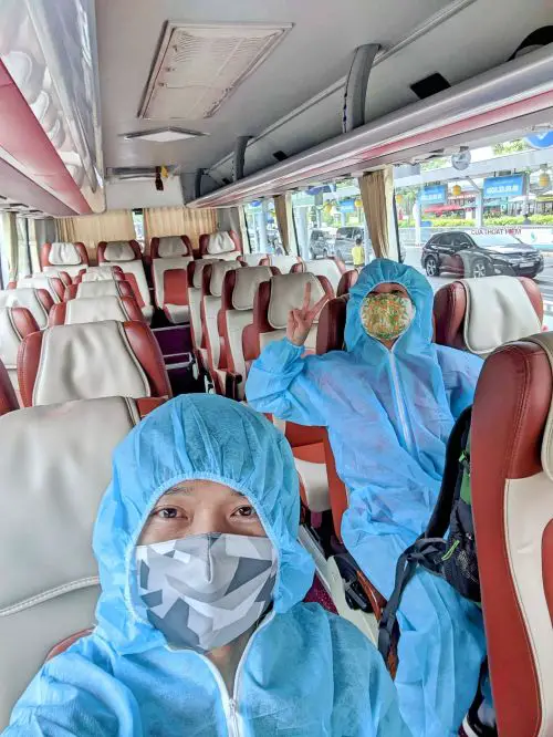 Justin Huynh and Jackie Szeto, Life Of Doing, wear the full body PPE outfit and riding an empty shuttle to go to the quarantine hotel
