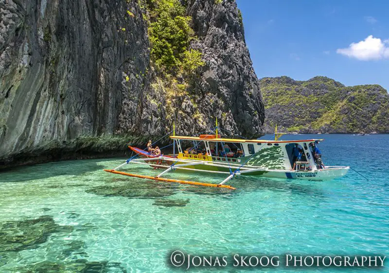 People on a boat in the clear blue waters of El Nido, Philippines