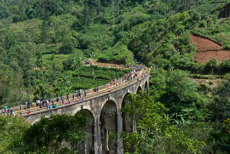 People standing along the Nine Arch Bridge and railroad tracks in Ella, Sri Lanka