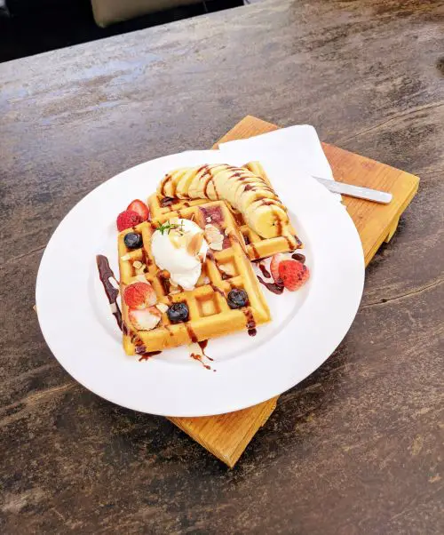 Two pieces of waffle with strawberry, banana, and blueberries at Tiệm Bánh Thành Hôn in Dalat, Vietnam