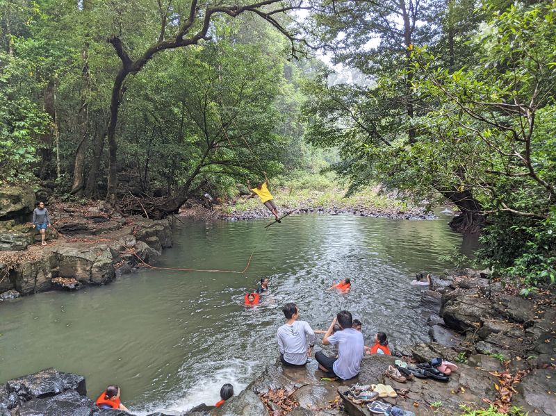 Groups of people swimming in the waters around the Bu Gia Map National Park campsite