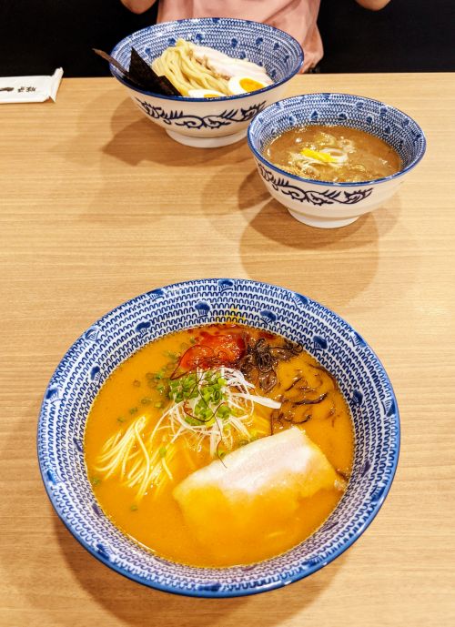 Two bowls of ramen at Ittou Ramen in Ho Chi Minh City. One has spicy ramen with charsiu. The other bowl has noodles and dipping sauce.