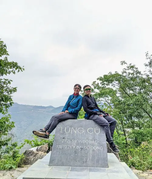 Jackie Szeto and Justin Huynh, Life Of Doing, sit on top of the Lung Cu sign
