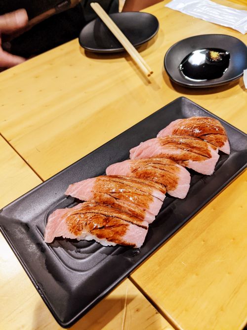 Five pieces of pink fatty tuna (otoro) on a plate at Sushi Tiger, Ho Chi Minh City