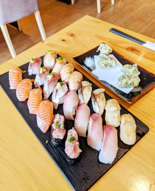 A plate of 22 sushi nigiri pieces and another plate of tempura mochi at Sushi Wagao, Ho Chi Minh City