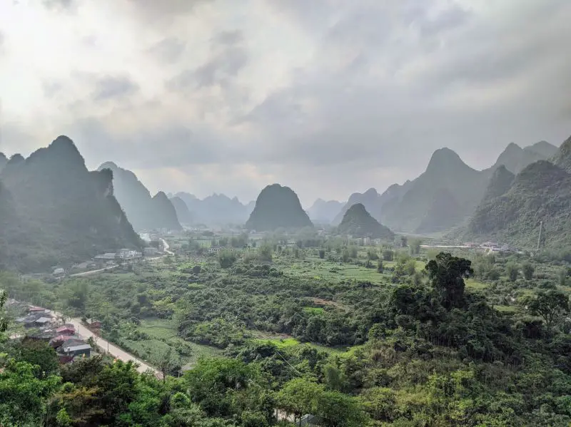 Sun peaking through the clouds of a village area with mountains and greenery in Cao Bang, Vietnam