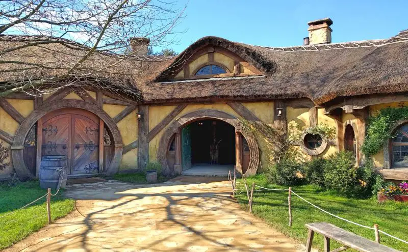 Outside of the Green Dragon Inn with the straw roof and circular door frames at Hobbiton Movie Set