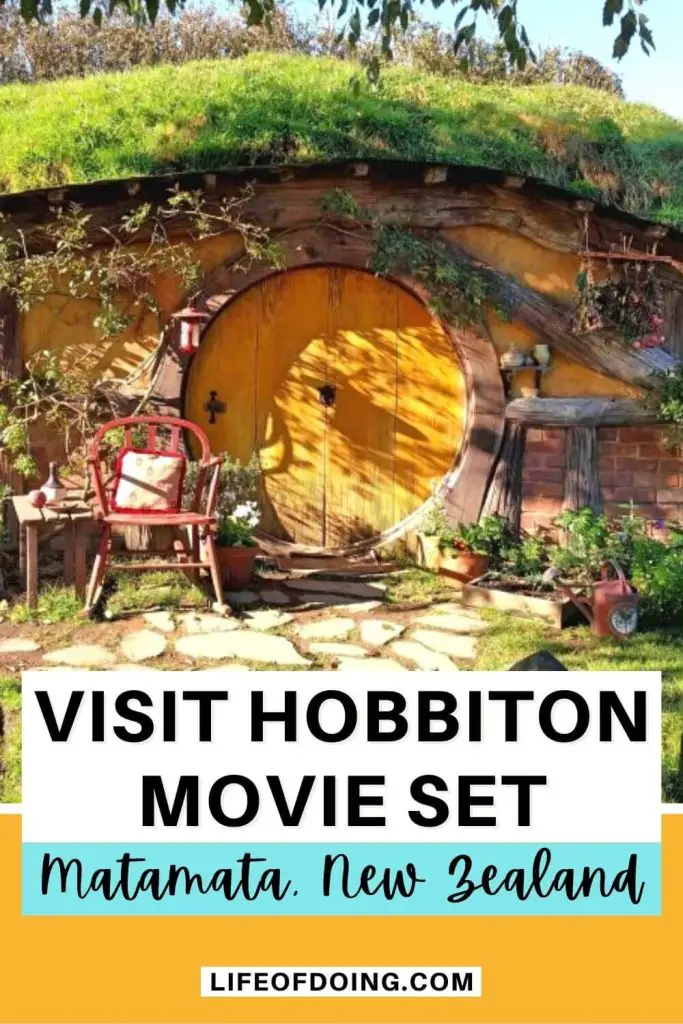 A hobbit hole with a yellow door, red chair, and garden at Hobbiton Movie Set in Matamata, New Zealand