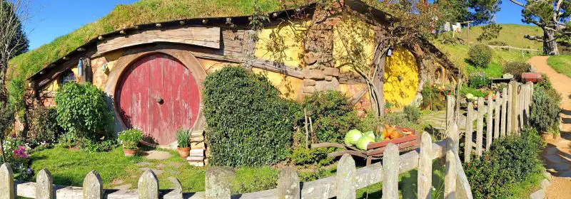 Replica of Sam Gamgee's hobbit hole with the red door and yellow paint at Hobbiton Movie Set